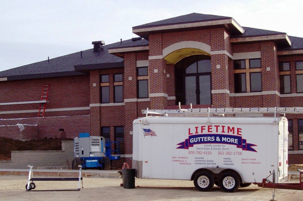 Lifetime Gutters trailer outside commercial building project.